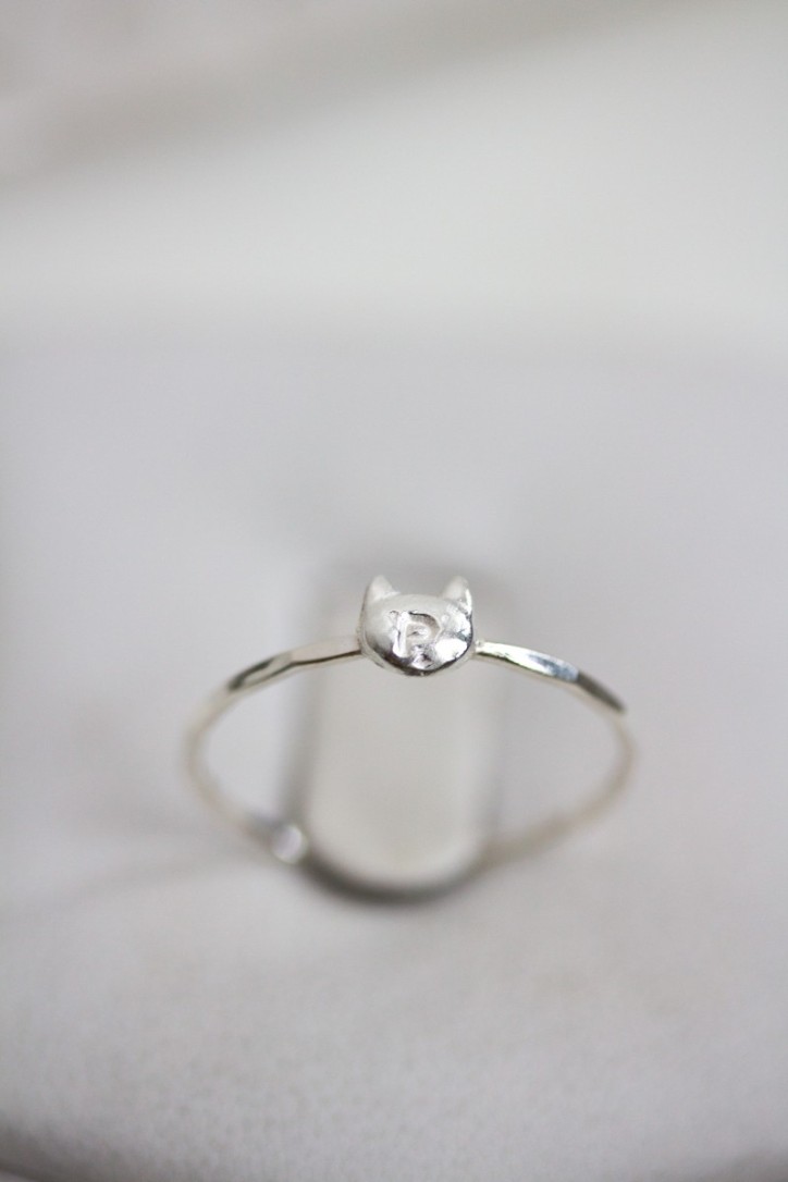 Initial ring with hand stamping in a cat head shape Initial ring with hand stamping in a cat head shape