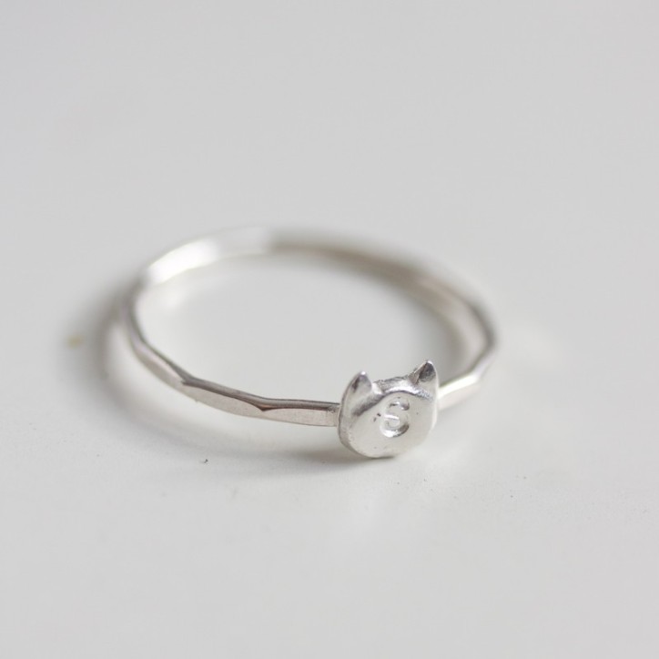 Initial ring with hand stamping in a cat head shape Initial ring with hand stamping in a cat head shape